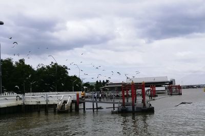 Boats moored in river against sky