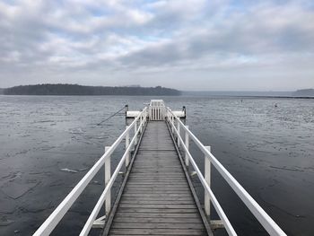 Jetty leading towards sea against sky