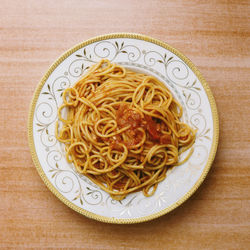 Directly above shot of spaghetti served in plate on wooden table