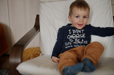 Portrait of boy sitting on sofa at home