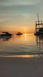 Silhouette boats in sea against sky during sunset