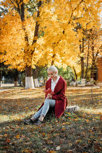 Beautiful blonde woman with autumn leaves on fall nature background. alone brooding woman 