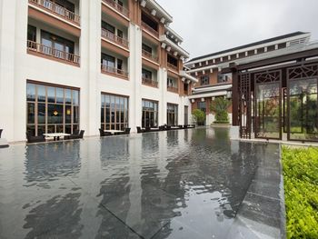 Reflection of buildings on wet street in rainy season