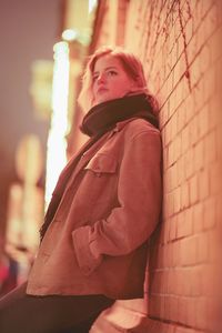 Portrait of woman standing against wall