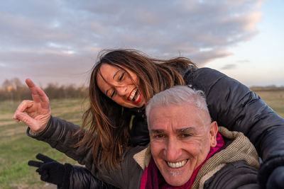 Portrait of smiling friends standing against sky