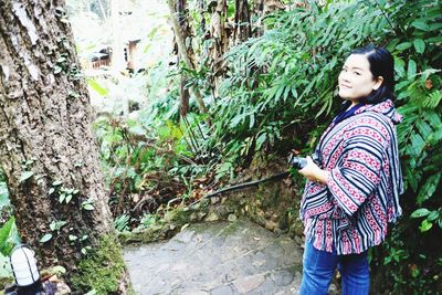 Side view of woman standing against plants