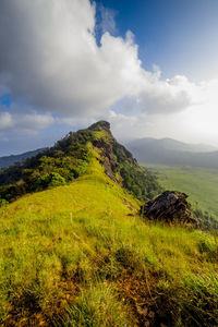 Scenic view of field and mountains against sky