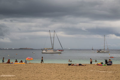 People at beach against sky