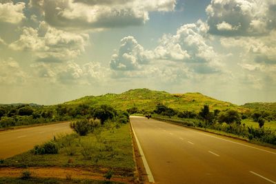 Road passing through landscape against sky