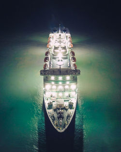 Digital composite image of illuminated ship in sea at night