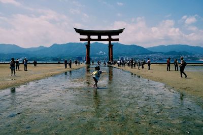 People at beach against sky