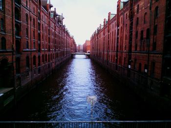 Canal amidst buildings against sky