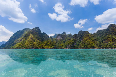 Scenic view of sea and mountains against sky