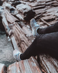 Low section of person sitting on wood