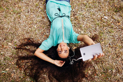 High angle portrait of woman lying down outdoors