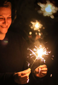 Woman holding burning at night