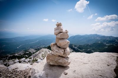 Stack of rocks on mountain against sky