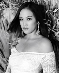 Portrait of young woman standing against plants