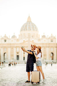 Rear view of woman with arms raised in city