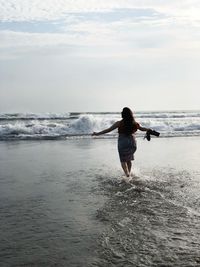 Rear view of man on sea against sky