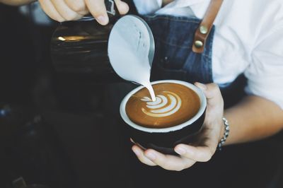 Midsection of woman holding coffee