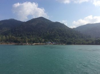 Scenic view of sea and mountains against sky