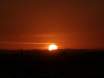 Scenic view of silhouette landscape against orange sky