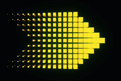 Close-up of illuminated yellow lights against black background