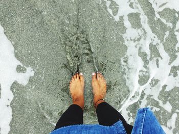 Low section of person standing in water