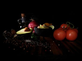 Close-up of fruits on table against black background