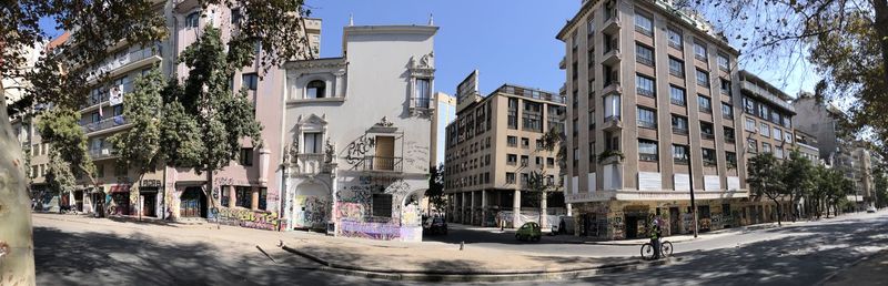 Street by buildings against sky in city