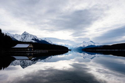 Scenic view of lake by snowcapped mountains against sky