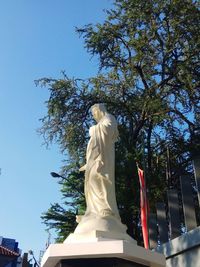 Low angle view of statue against blue sky