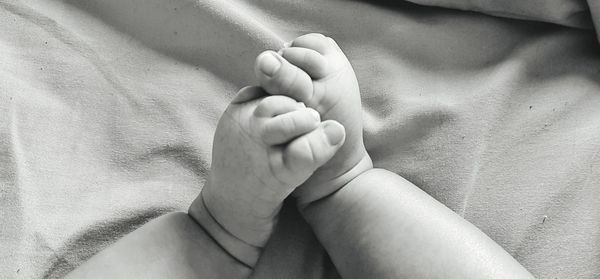 Close-up of baby hand on bed