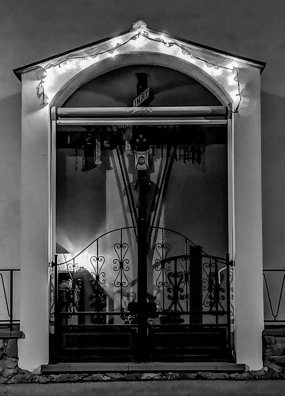 LOW ANGLE VIEW OF ILLUMINATED BUILDING AT ENTRANCE