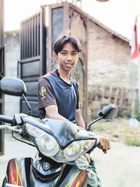 Portrait of young man riding motorcycle on street