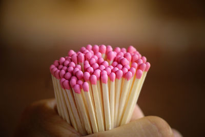 Cropped hands holding pink matchsticks