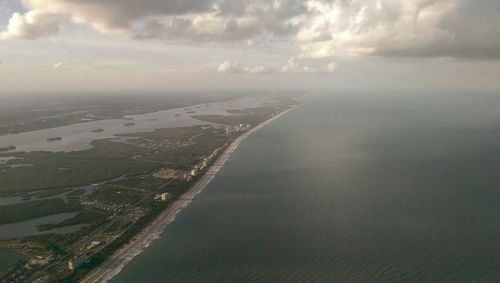 Aerial view of sea against cloudy sky