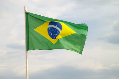 Low angle view of yellow flag against sky