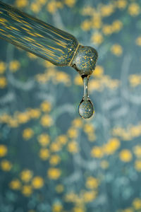 A dripping pipette with a drop of cosmetics gel.