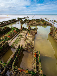 View across a seashell and algae covered wreck leftovers from a world war ship in northern france