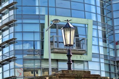 Low angle view of street light against modern building