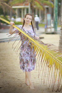 Portrait of young woman standing at beach