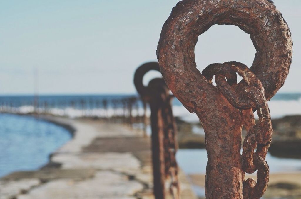 metal, rusty, focus on foreground, close-up, metallic, water, sea, chain, protection, safety, strength, weathered, old, security, day, outdoors, sky, railing, connection, no people