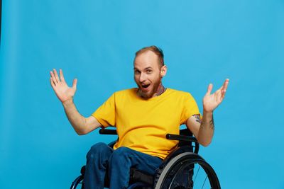 Portrait of boy playing with bicycle against clear blue sky