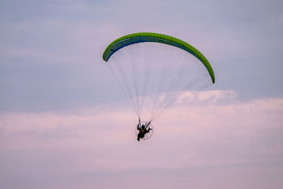 Person paragliding against sky during sunset