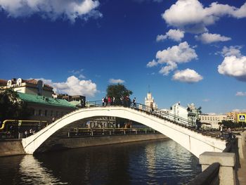 Bridge over river in city against sky
