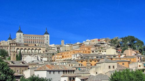 View of buildings in city against blue sky