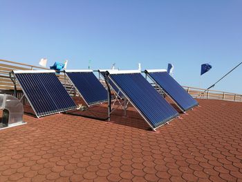 Solar panels on roof of house against blue sky