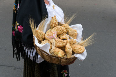 Low section of woman holding ice cream cone on street